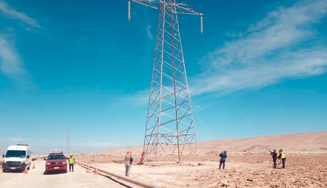 Cuadrilla trabajando al pie de una torre de alta tensión